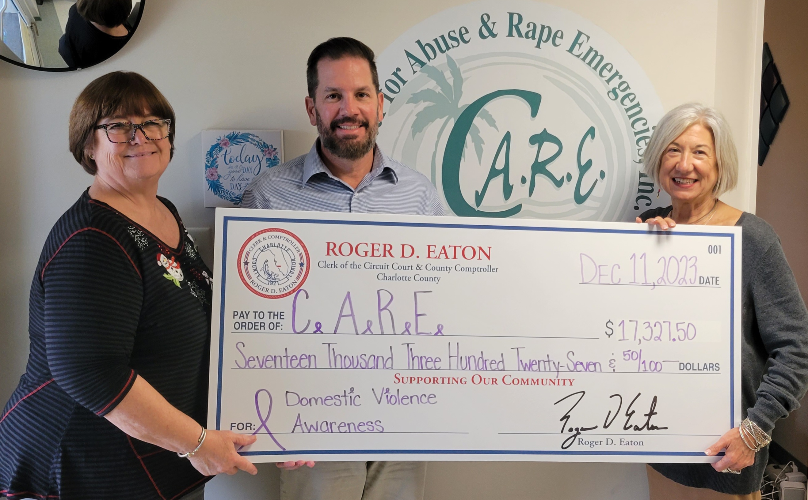 Roger D. Eaton, Clerk of the Circuit Court and County Comptroller presents check to CARE.